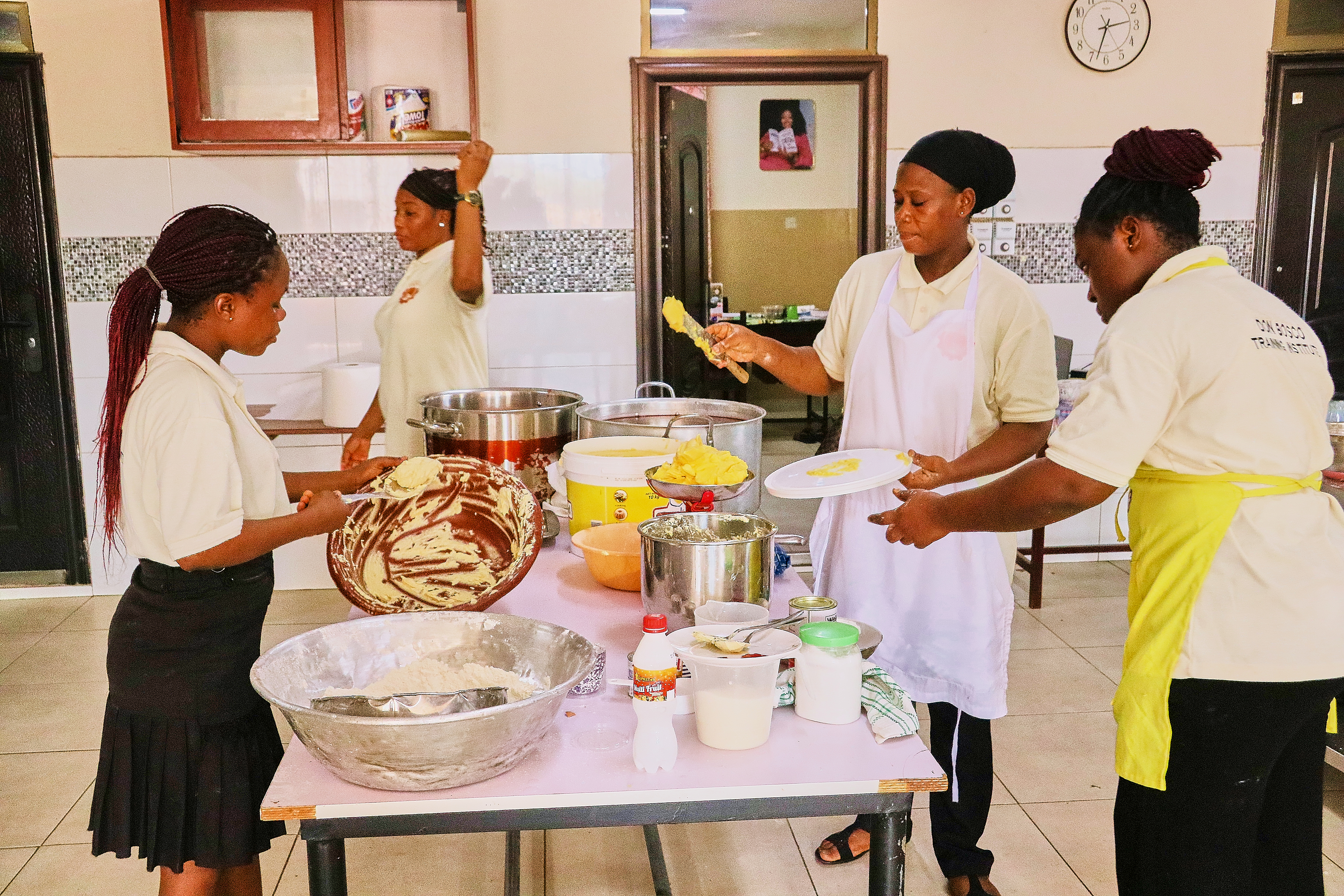 Practical culinary arts training with trainees kneading dough and preparing pastry recipes